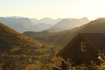 sunlight shining on a mountain cabin 
