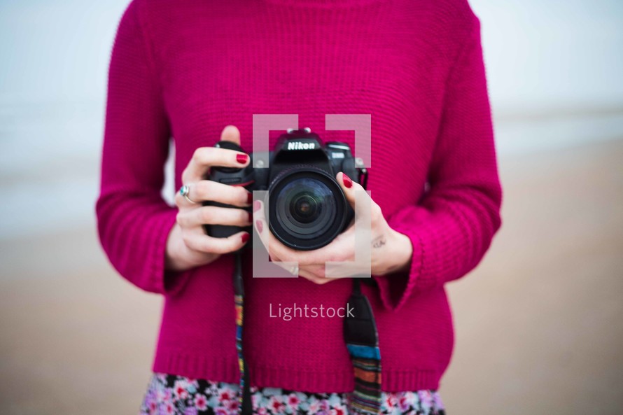 a woman photographer holding a camera 