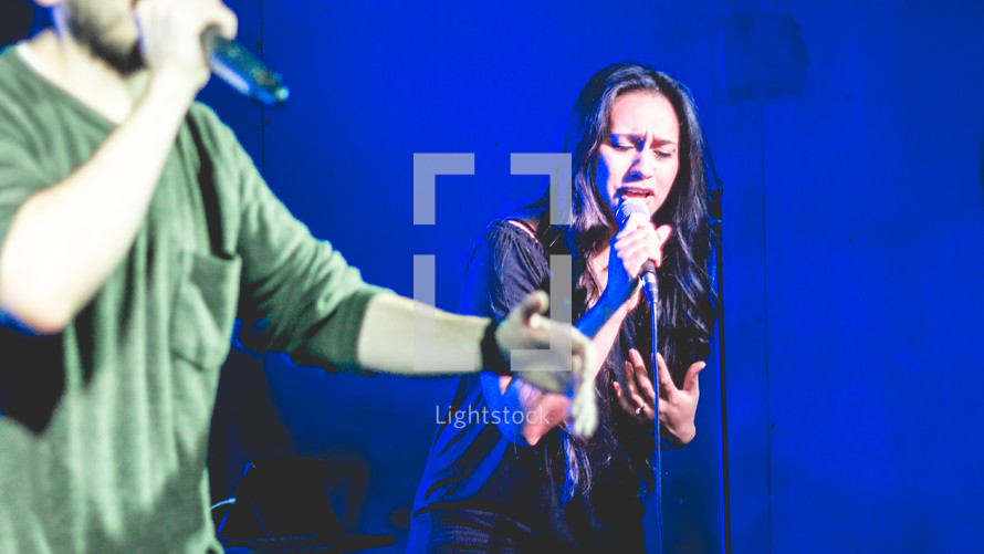 people singing on stage during a worship service 