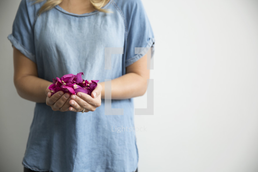 cupped hands holding rose petals 