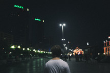 pedestrians walking on a city sidewalk at night 