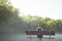 Woman sitting on a park bench .