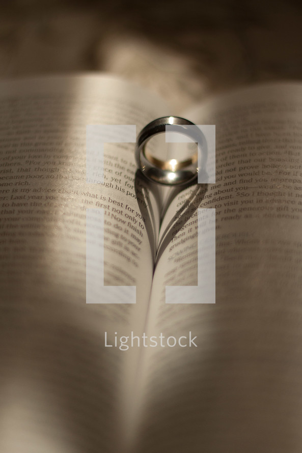 Wedding bands between the pages of a Bible. 