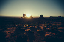 Sunset on a desert landscape with silhouettes of buttes.