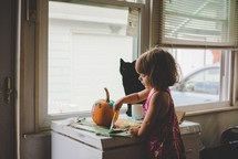 kid painting a pumpkin