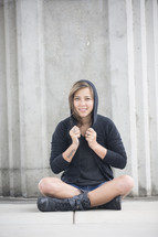woman sitting wearing a hoodie 