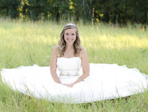bride sitting in the grass
