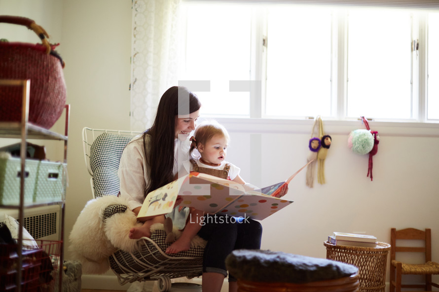 a mother reading a book to her daughter 