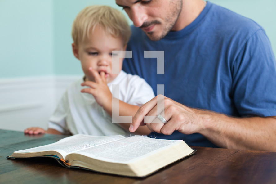 morning devotional - man and his toddler son reading a Bible and a cup of coffee 