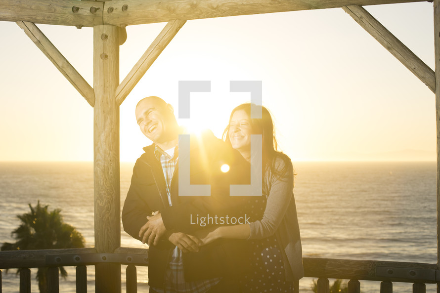couple laughing under intense sunlight 