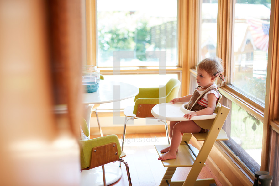 a toddler girl in a highchair 