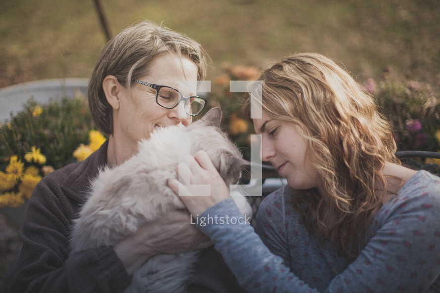 A mother and daughter petting their cat