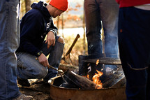 men standing around a campground fire 