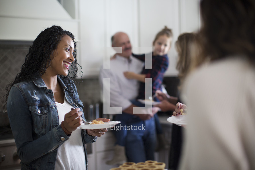 family gathered in the kitchen to get dessert at Thanksgiving 