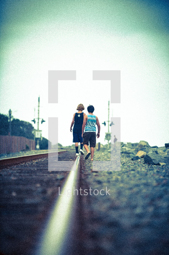 teen boys walking on tracks 