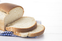 Freshly Baked Loaf of Homemade White Bread Sliced on a White Table