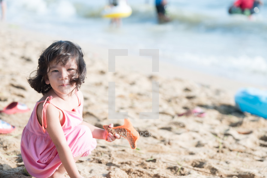little girl playing on a beach 