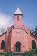 brick church and a woman standing in the doorway 