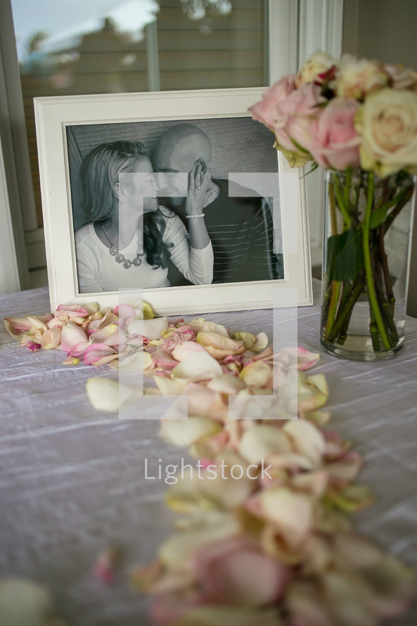 framed picture of a couple and rose petals 