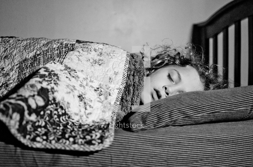child sleeping in a bed