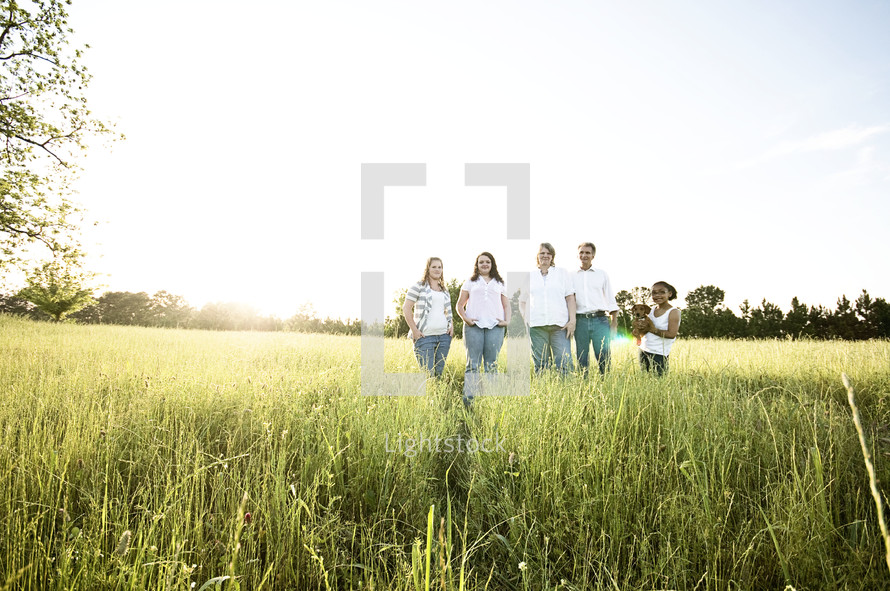 family standing together outdoors in a field