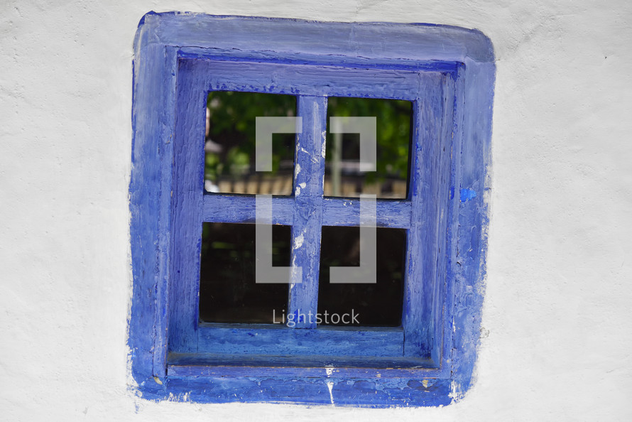 Closed vintage blue window on white wall of old house in romania