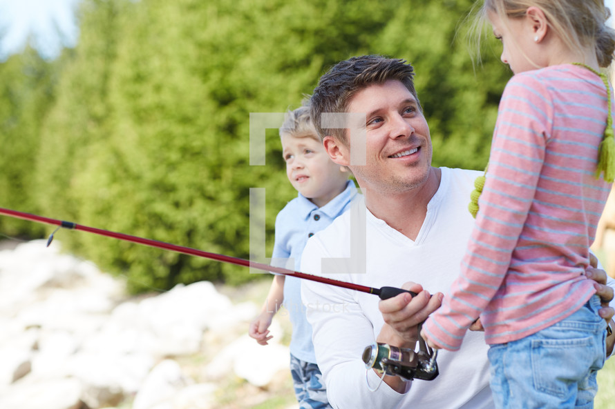 a father fishing with his children 