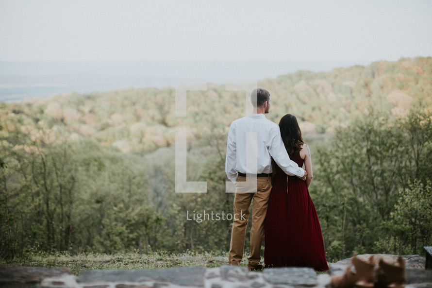 couple standing on a hillside 
