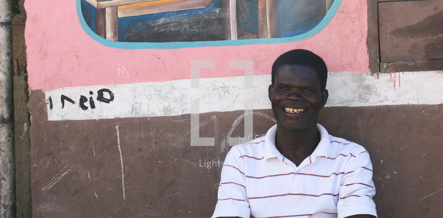 a smiling man sitting outdoors in Haiti 