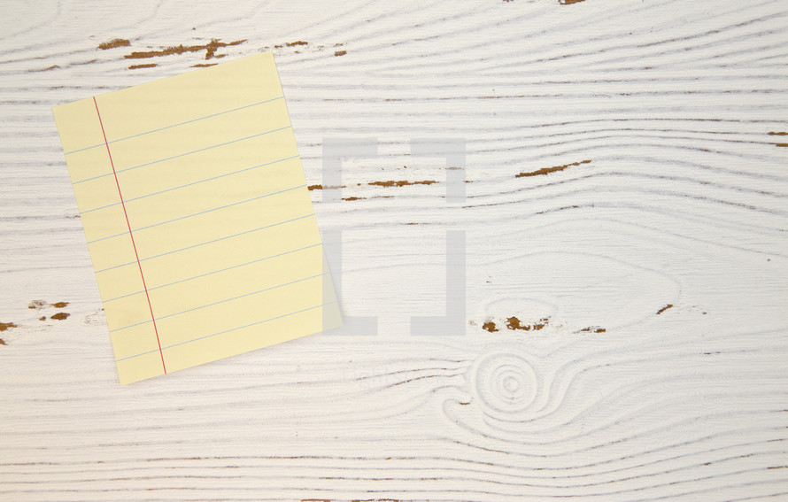 lined paper on white wood background 