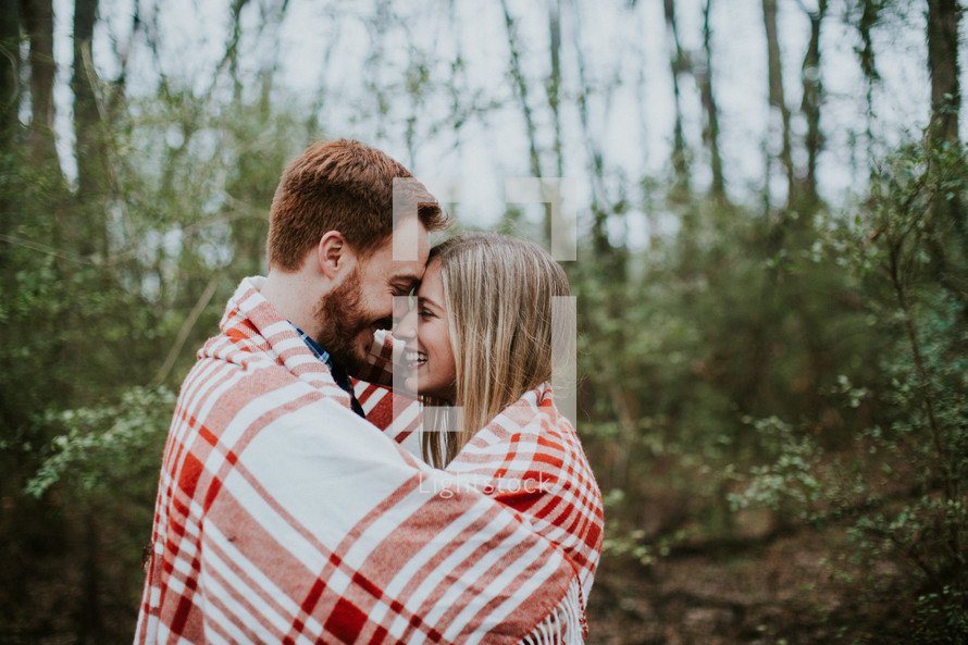 couple wrapped up in a plaid blanket 