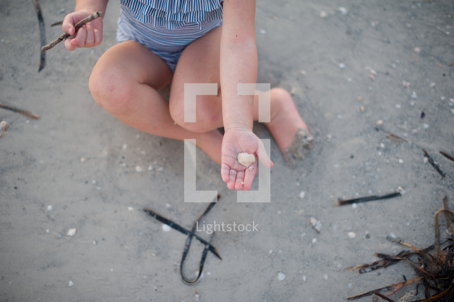girl child sitting on a beach 