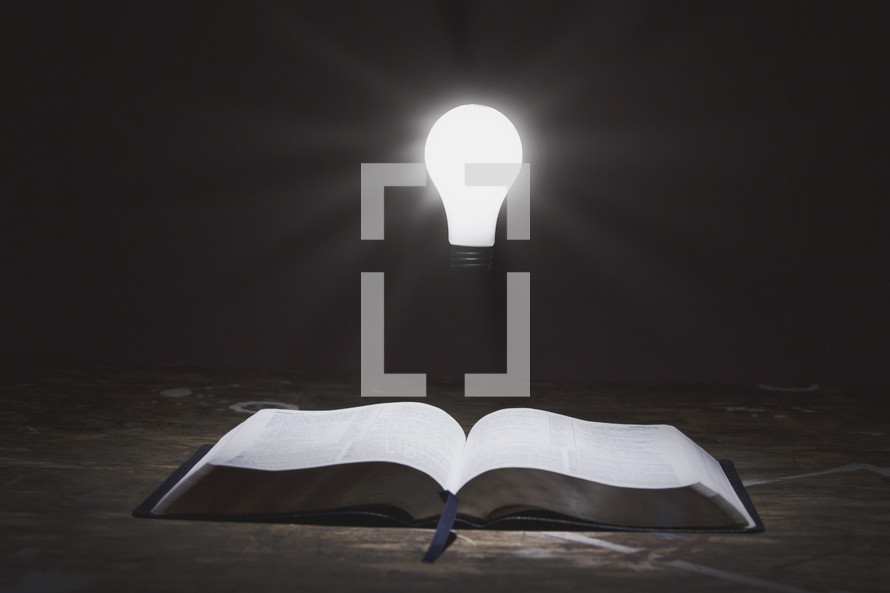 glowing lightbulb and an open Bible