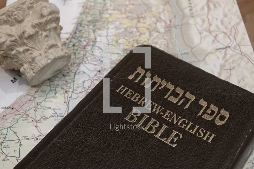 The Bible in Hebrew and English on top of a map of Israel.