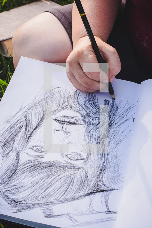 woman sketching on a sketch pad 