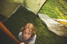 A child setting up a tent. 