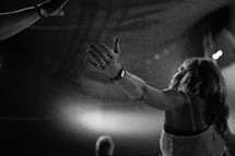A woman with arms outstretched during a church service.