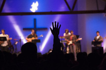 Silhouette of raised hand in the audience of a Christian concert.