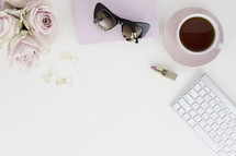 roses, notebook, sunglasses, lipstick, coffee mug, clips, and computer keyboard 