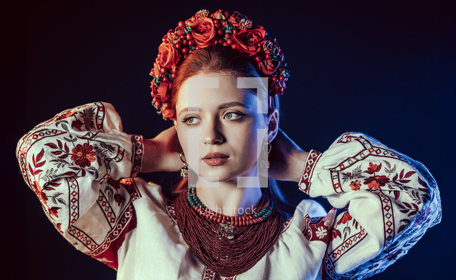 Charming ginger woman in traditional ukrainian handkerchief, necklace and embroidered blouse at black background. Ukraine, style, folk, ethnic culture. High quality photo