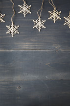 border of snowflake ornaments on a wooden background. 