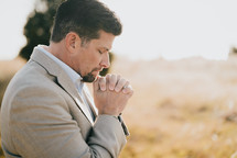 a man praying in a field 