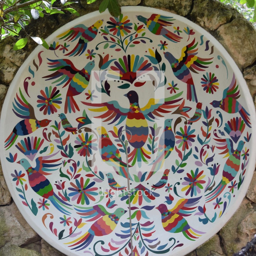 colorful birds painted onto a white plate 