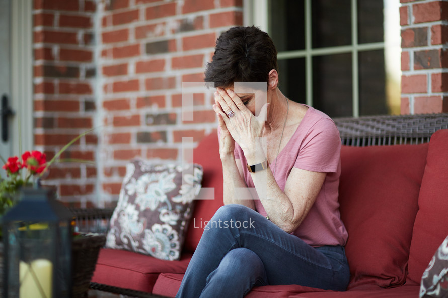 a woman covering her face with her hands 