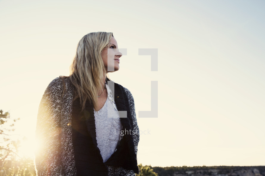 sunburst and blonde woman standing outdoors 