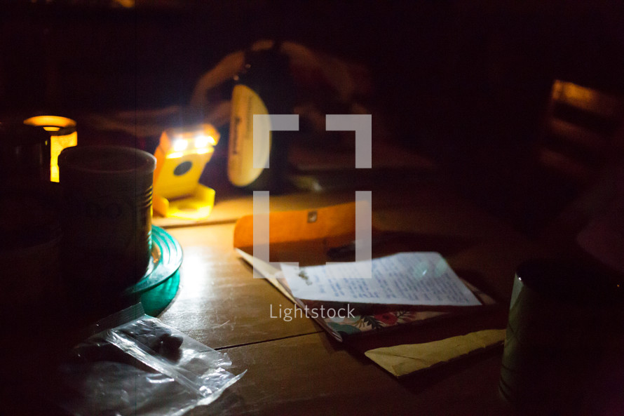 a flashlight on a table lighting a work space 