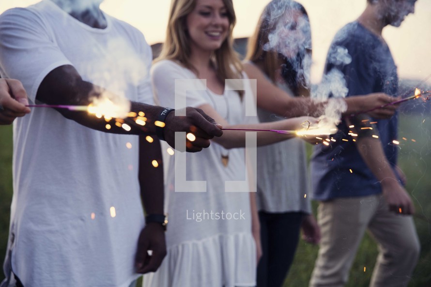 men and women holding sparklers 