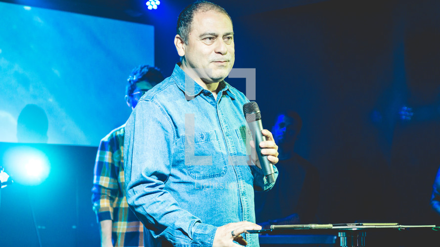 a pastor holding a microphone 