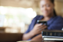 Woman texting near a Bible.