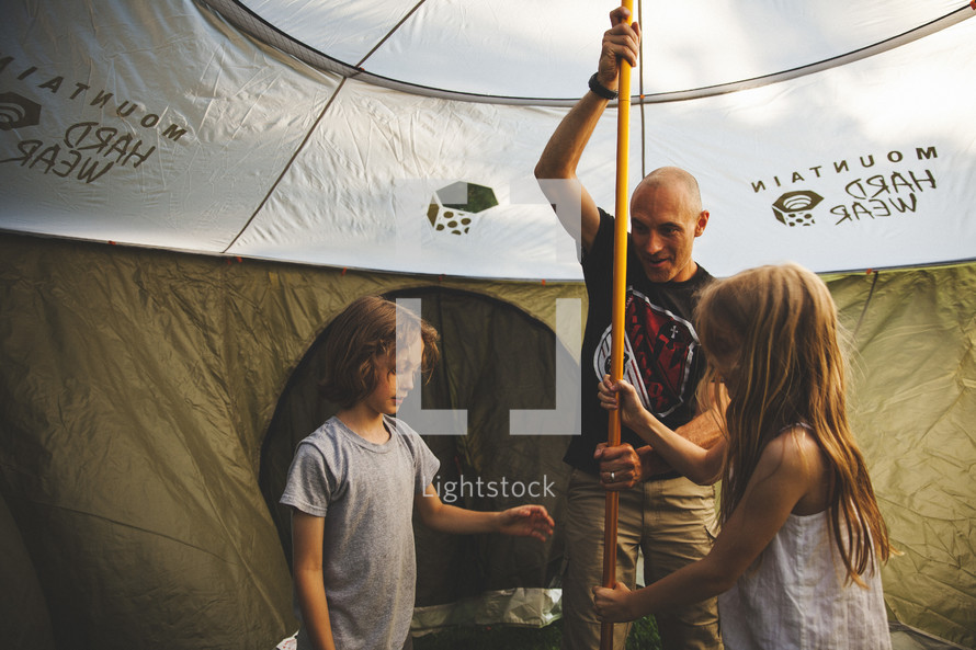 A family setting up a tent. 
